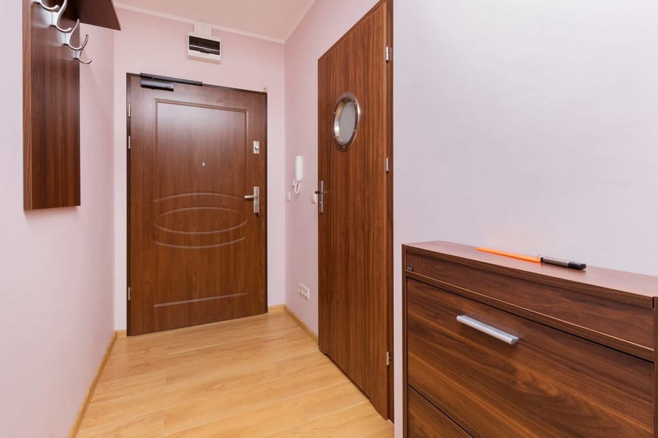 Hallway with wooden doors, bright lighting, and a clean, welcoming design.
