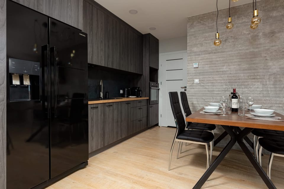 A close-up of a sleek kitchen with dark cabinets, a stove, and modern appliances.