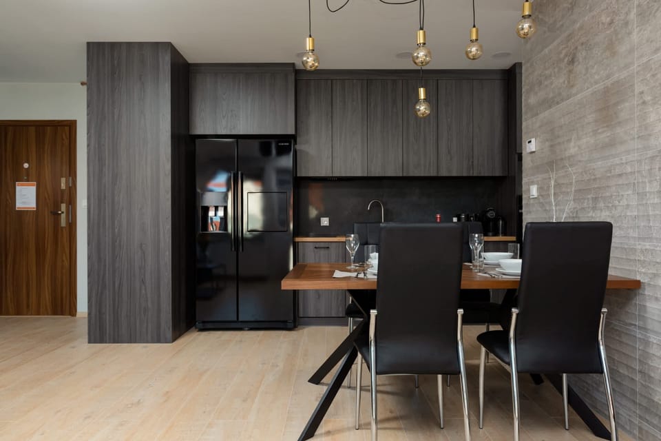 A modern kitchen with dark cabinets, sleek countertops, and integrated appliances for a minimalist look.