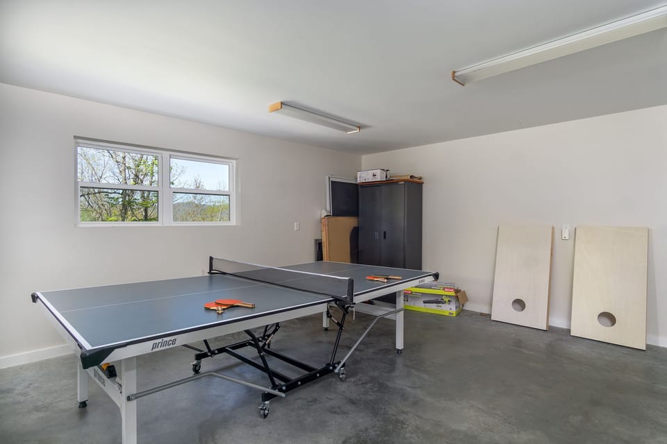 Game room in the garage with ping-pong table & cornhole.