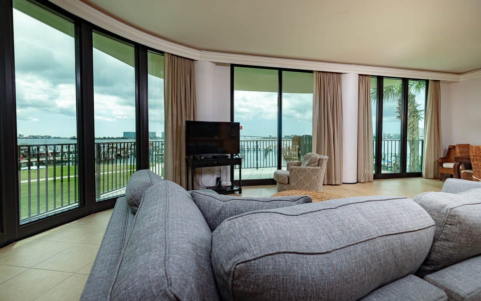 Unwind on the plush sofa while enjoying breathtaking panoramic views of the bay through expansive windows
