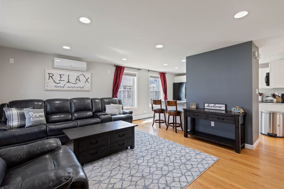 Living room with oversized leather reclining couch, recliner and 60" smart tv