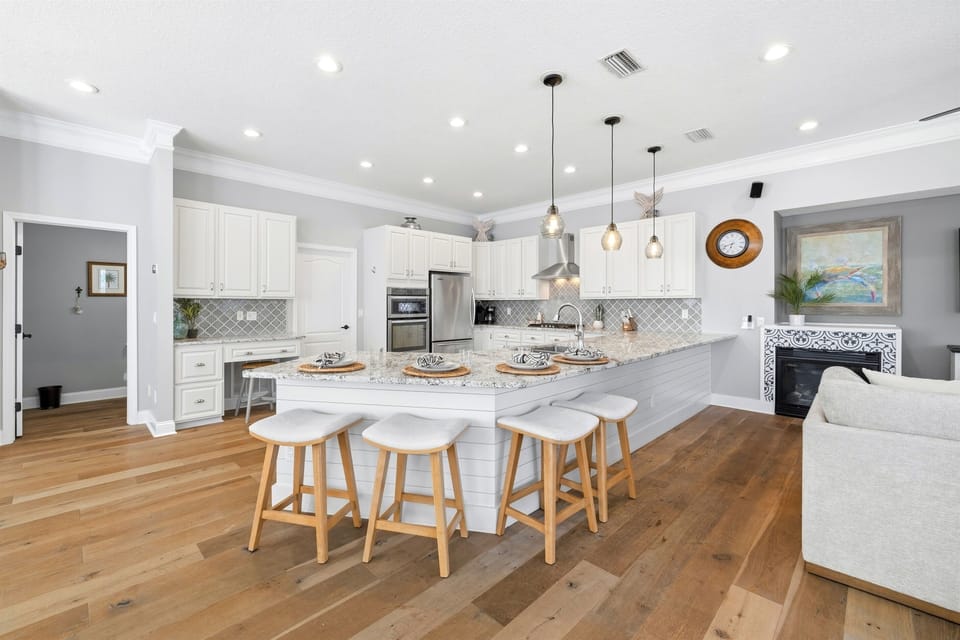Oversized peninsula with bar seating anchors this bright, open kitchen — ideal for casual breakfasts, snacks, and gathering together.