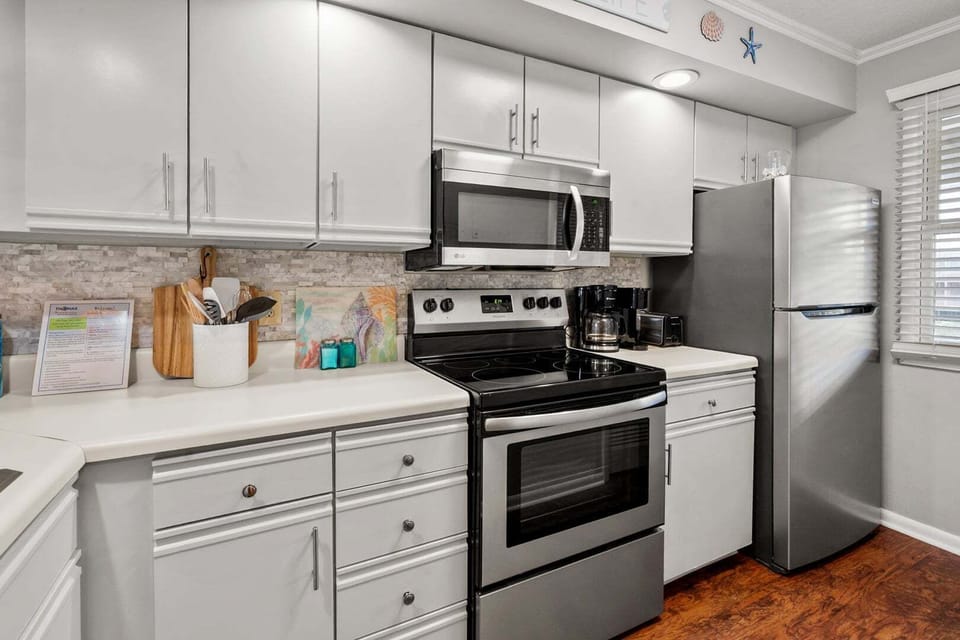 Kitchen with white cabinetry, a range and full-size refrigerator at Sandwedge 206 in Ocean Drive