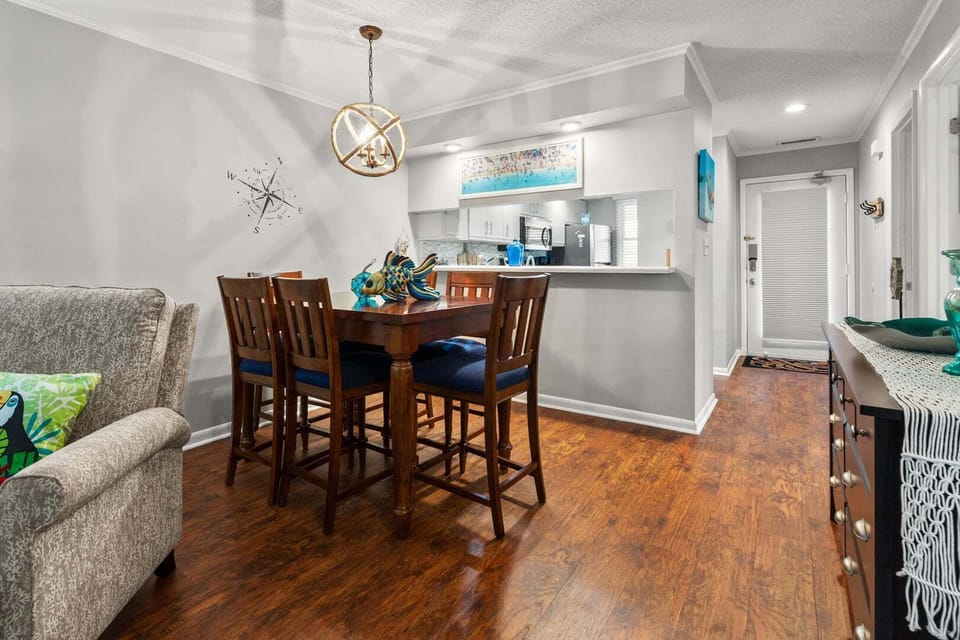 Dining table set for six beside the kitchen counter at Sandwedge 206, an Ocean Drive vacation rental