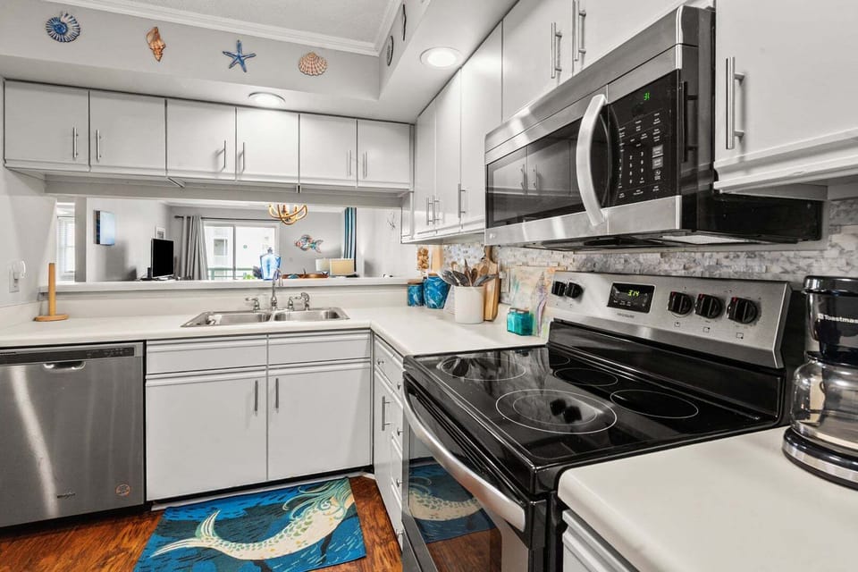 Under-cabinet lighting and marine decor in the kitchen at Sandwedge 206, an Ocean Drive condo rental