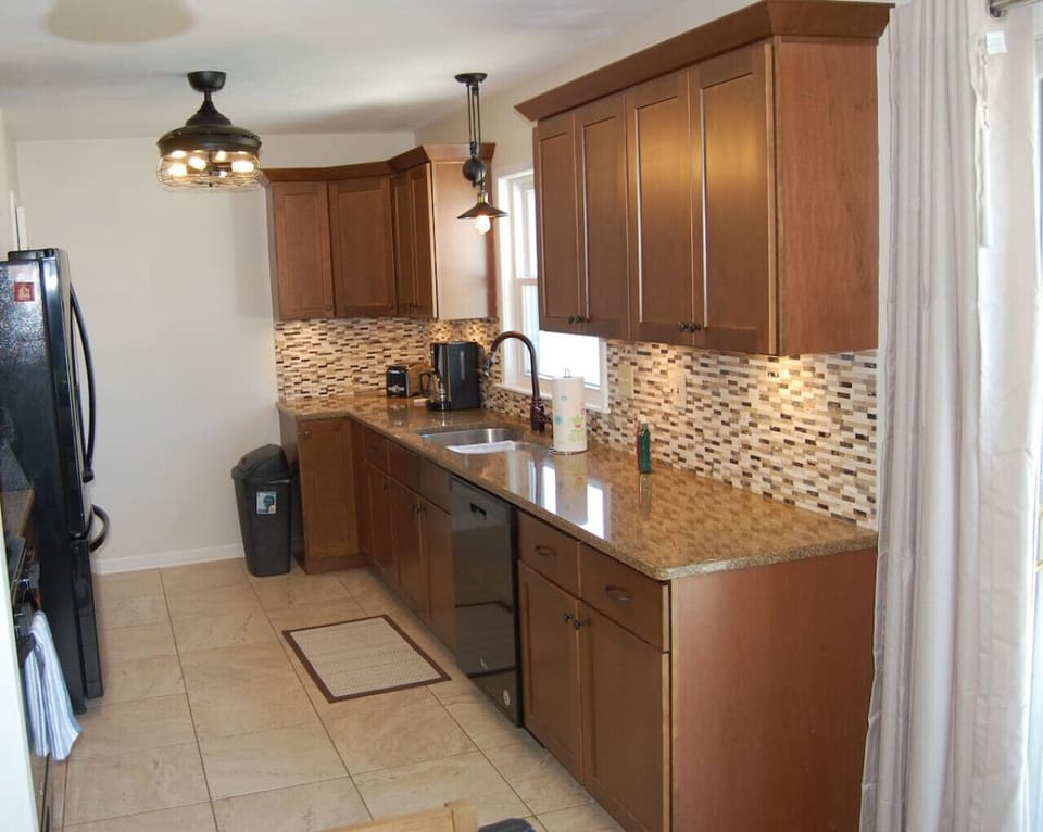 Our gally style kitchen is fully stocked with pots, pans, baking items, dinner plates, utensils, and more.