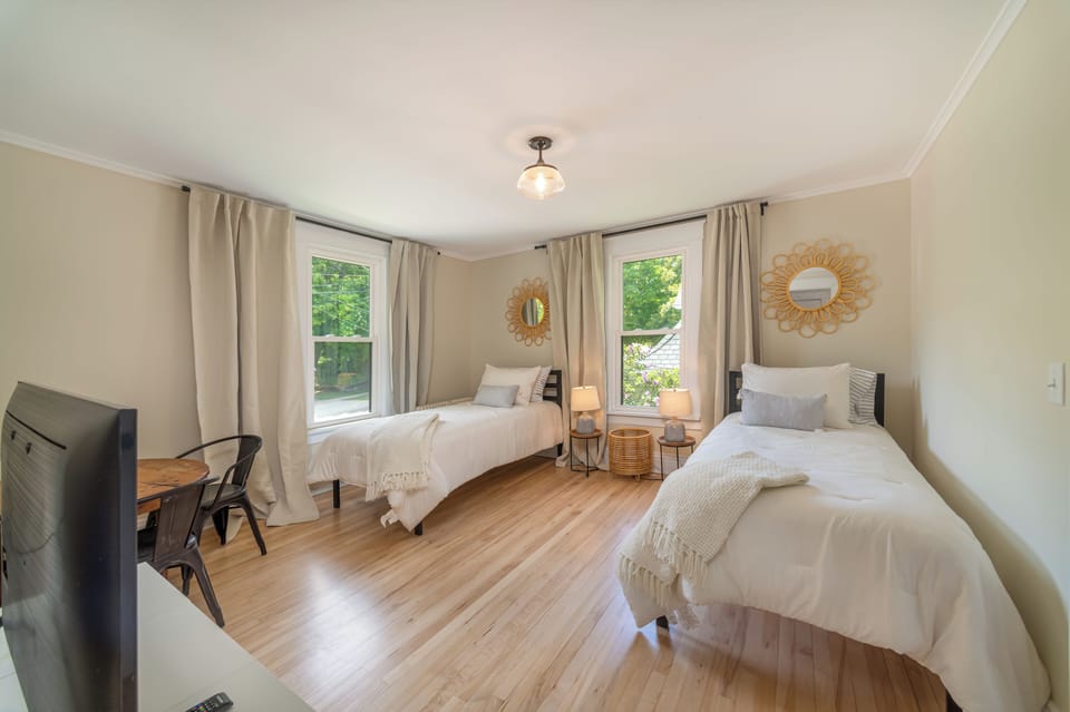 Upstairs bedroom with two twin beds, 43" tv, table and chairs