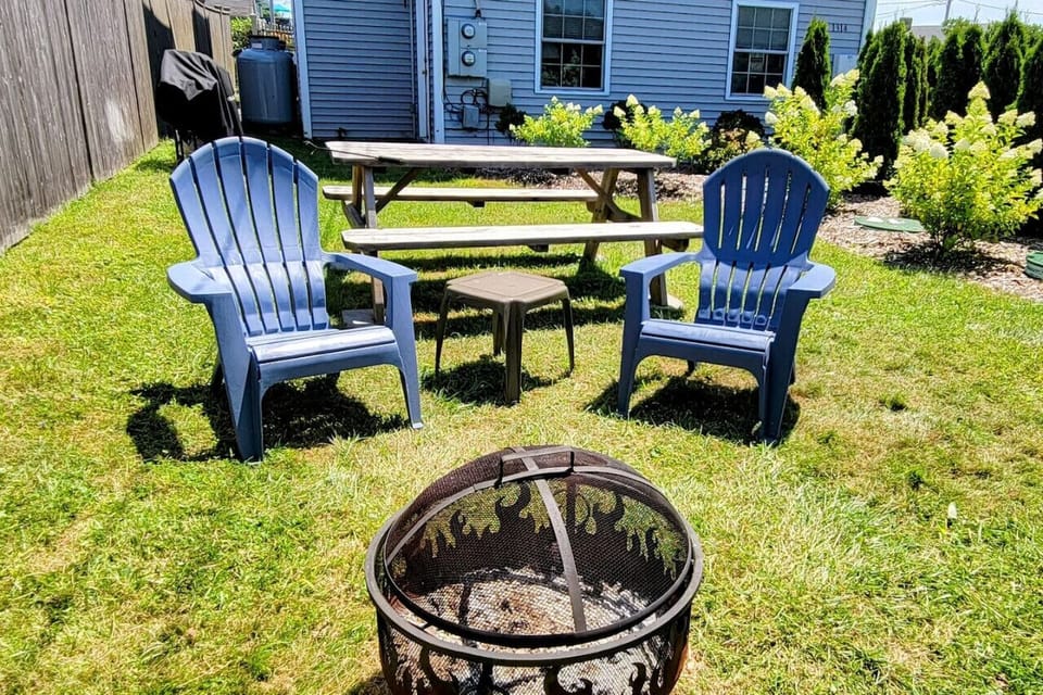 Adirondacks and fire pit in private garden area.