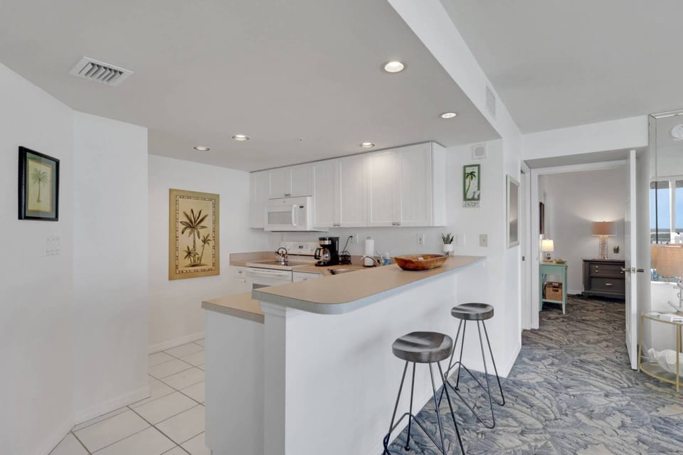 An eating bar with 2 bar stools separates the kitchen from the living area.