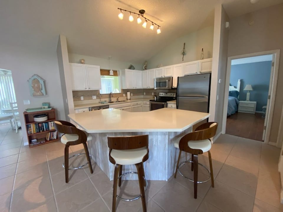 kitchen with counter island with three high chairs