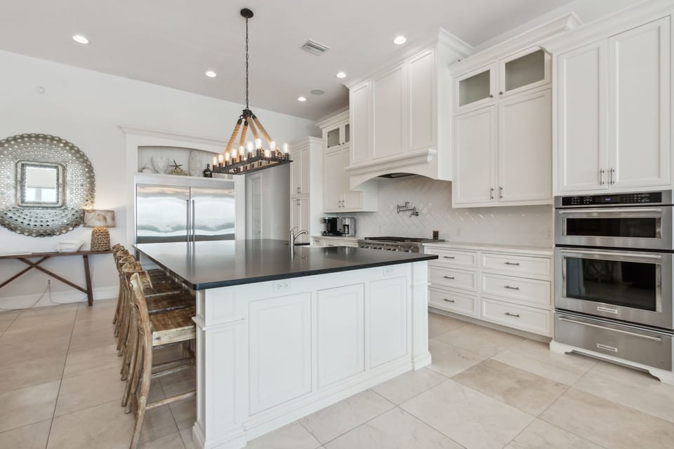 Fully Equipped Kitchen with Oversized Island, Stainless Steel Appliances, Farm Sink, Gas Stove, and Bar Stool Seating