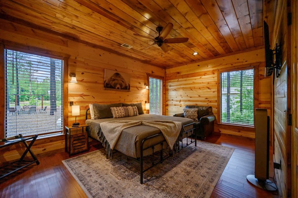 Bedroom #2 with tv, couch, luggage holder, privacy blinds, and private bathroom.