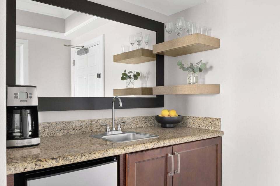 Kitchenette includes a sink, coffee maker, and small refrigerator.