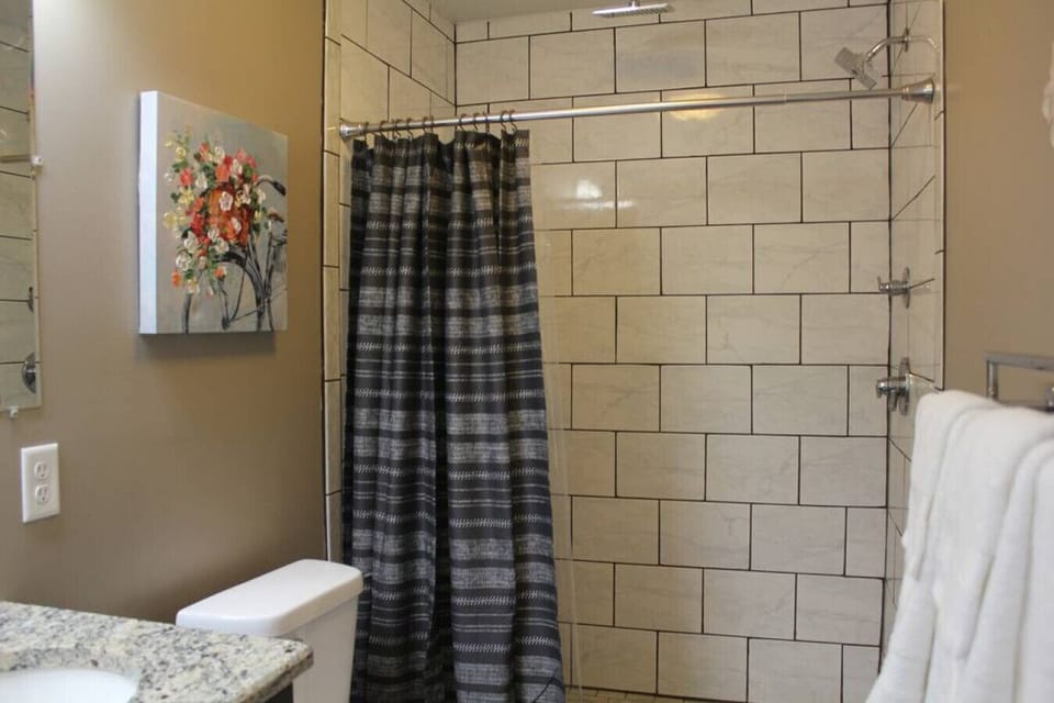 Experience a revitalizing escape in our short-term rental's invigorating shower area. Step into a world of relaxation as you indulge in the modern comforts and rejuvenating ambiance of this thoughtfully designed space.
