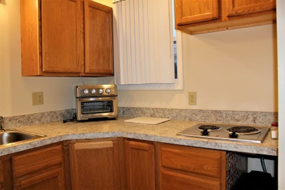 Discover the culinary possibilities in our well-appointed kitchen within our studio apartment short-term rental. Designed with efficiency and style in mind, our kitchen offers a compact yet fully functional space for all your cooking needs. The modern app