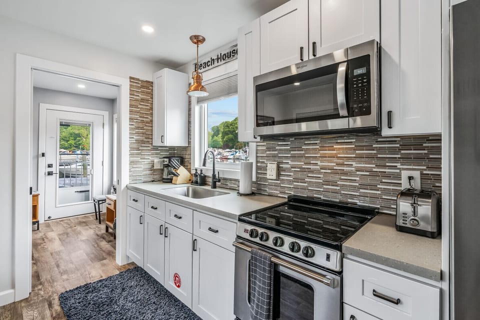 Fully equipped kitchen featuring stainless steel appliances, spacious countertops, and marina views.