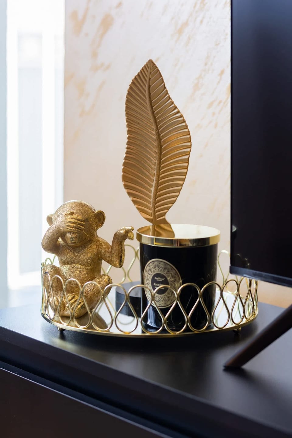 A decorative display with a golden leaf ornament on a black countertop, adding elegance to the interior.

