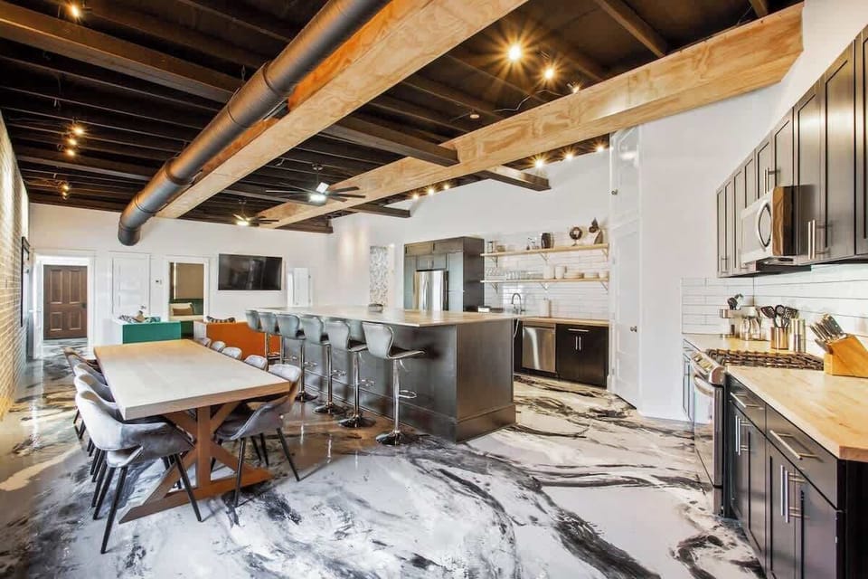 Expansive open-concept kitchen and dining space with a large island, bar seating, and 
Here your group will enjoy an ample kitchen space, a dining table that will fit everyone, and three couches to lounge on in from of the large flat screen smart TV.