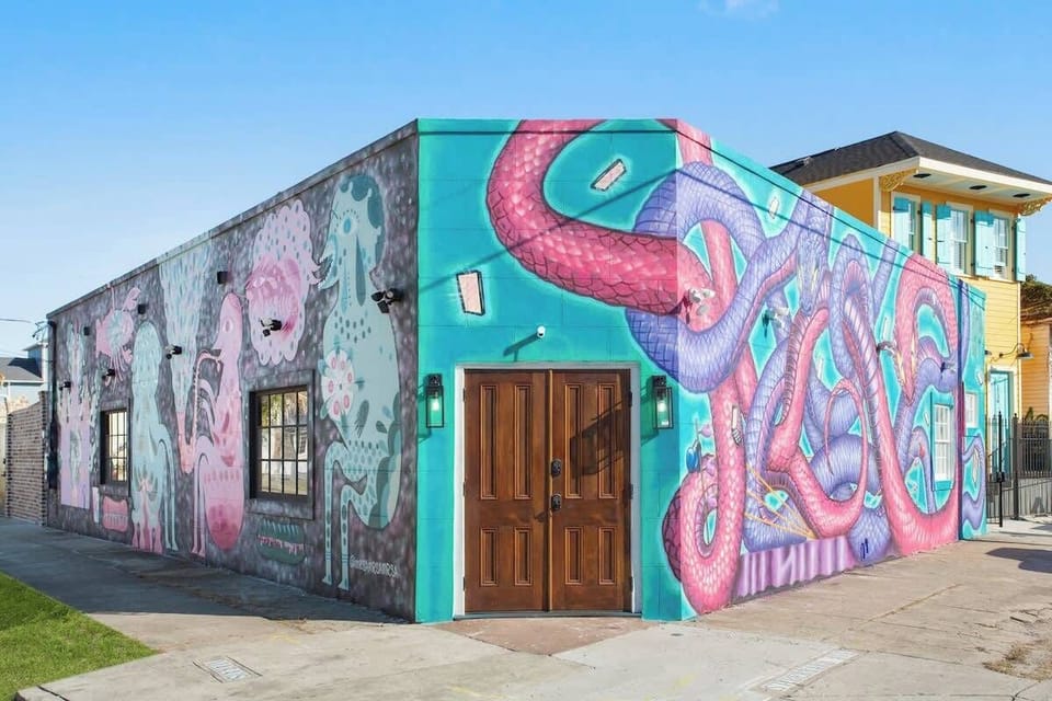 Colorful mural-covered exterior showcasing vibrant local art and character. A unique, eye-catching space that captures the creative spirit of New Orleans right outside your door.