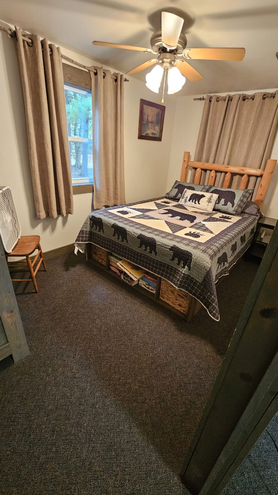 Bedroom 2 with a queen bed, ceiling fan, and a window box fan.