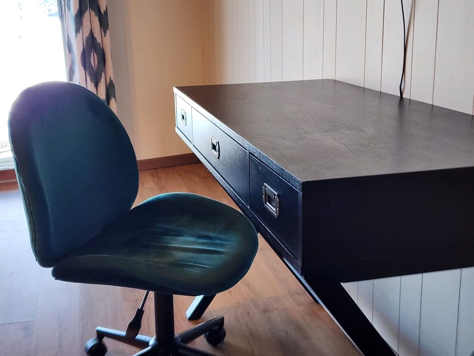 A desk and comfortable chair is setup in the basement bedroom.