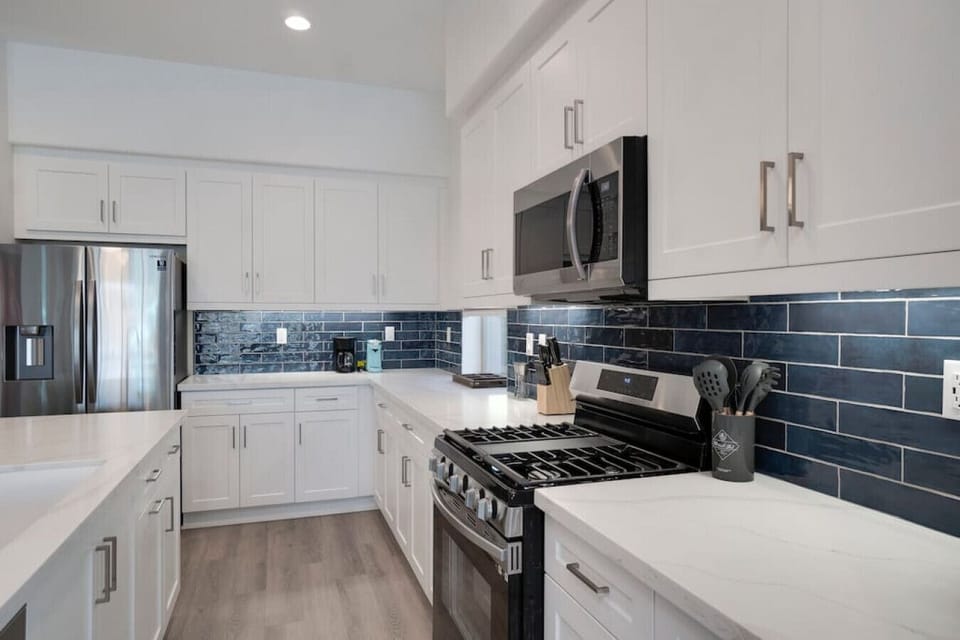 Contemporary kitchen w/ gas range, glossy tile backsplash & ample counter space