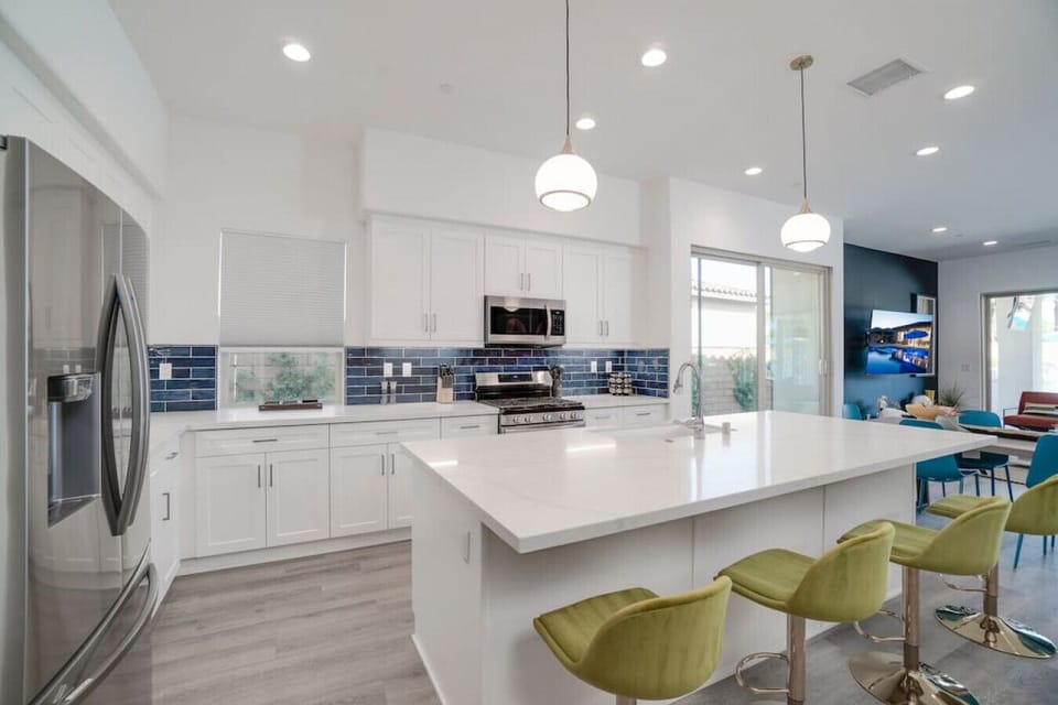 Sleek white kitchen w/ spacious island, bar seating & modern finishes throughout