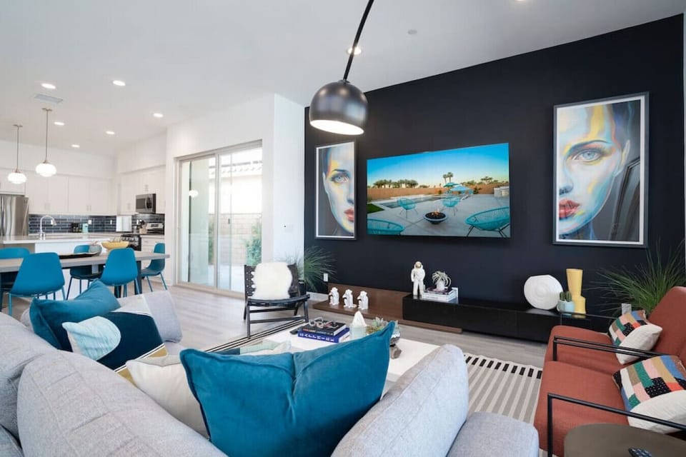 Bright living room w/ plush seating, bold art & large windows filling the space w/ light