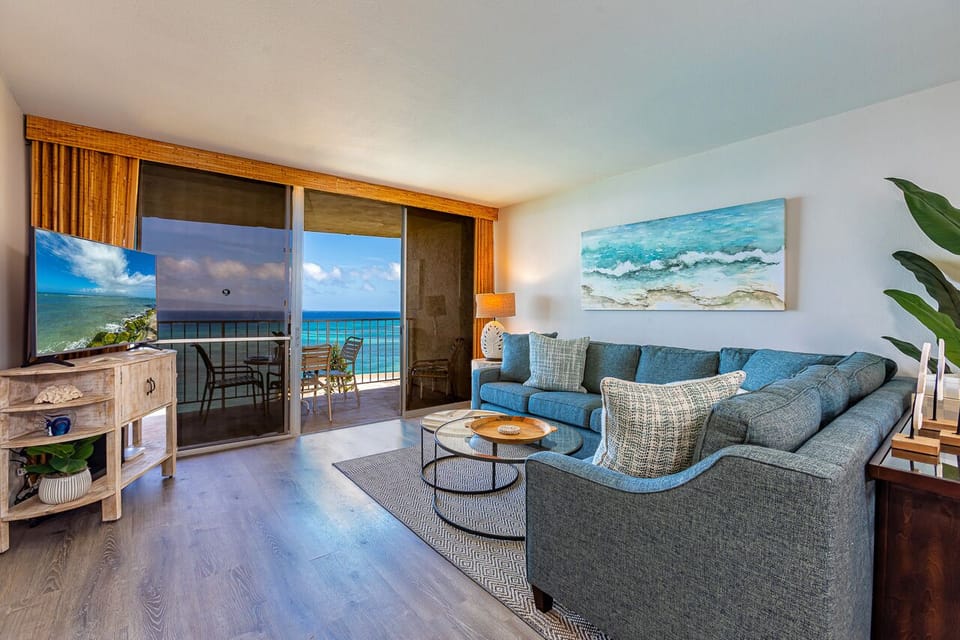 Sink into the plush sectional and let the ocean breeze drift in through your private balcony. Your coastal retreat awaits with stunning sea views and calming artwork that echoes the waves beyond.