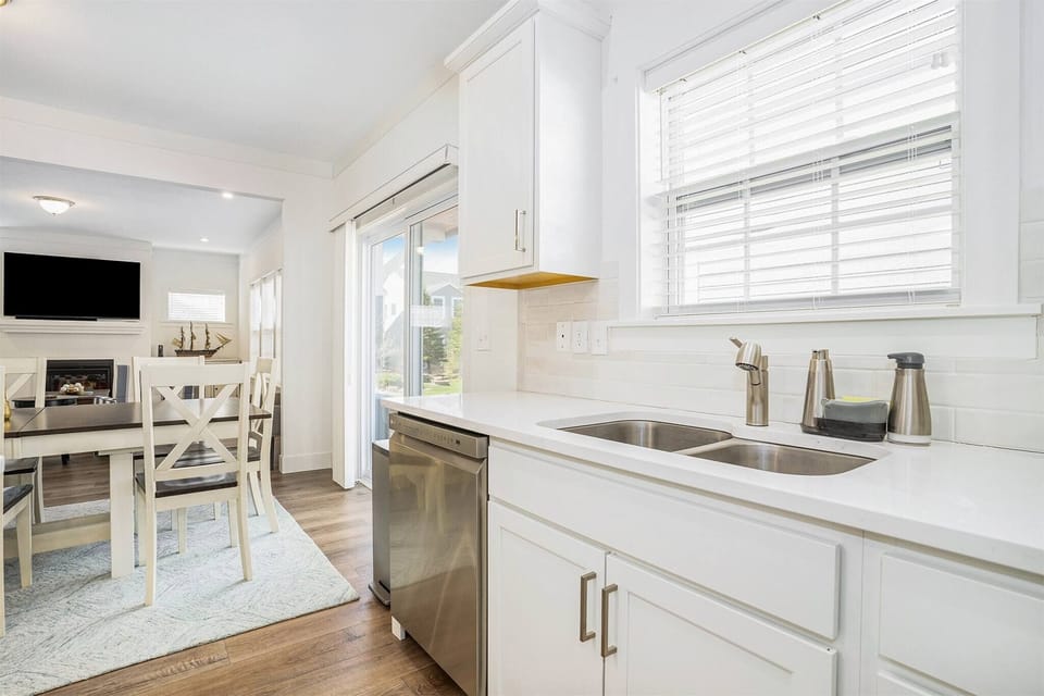 Double sinks, stainless dishwasher, and an open view.