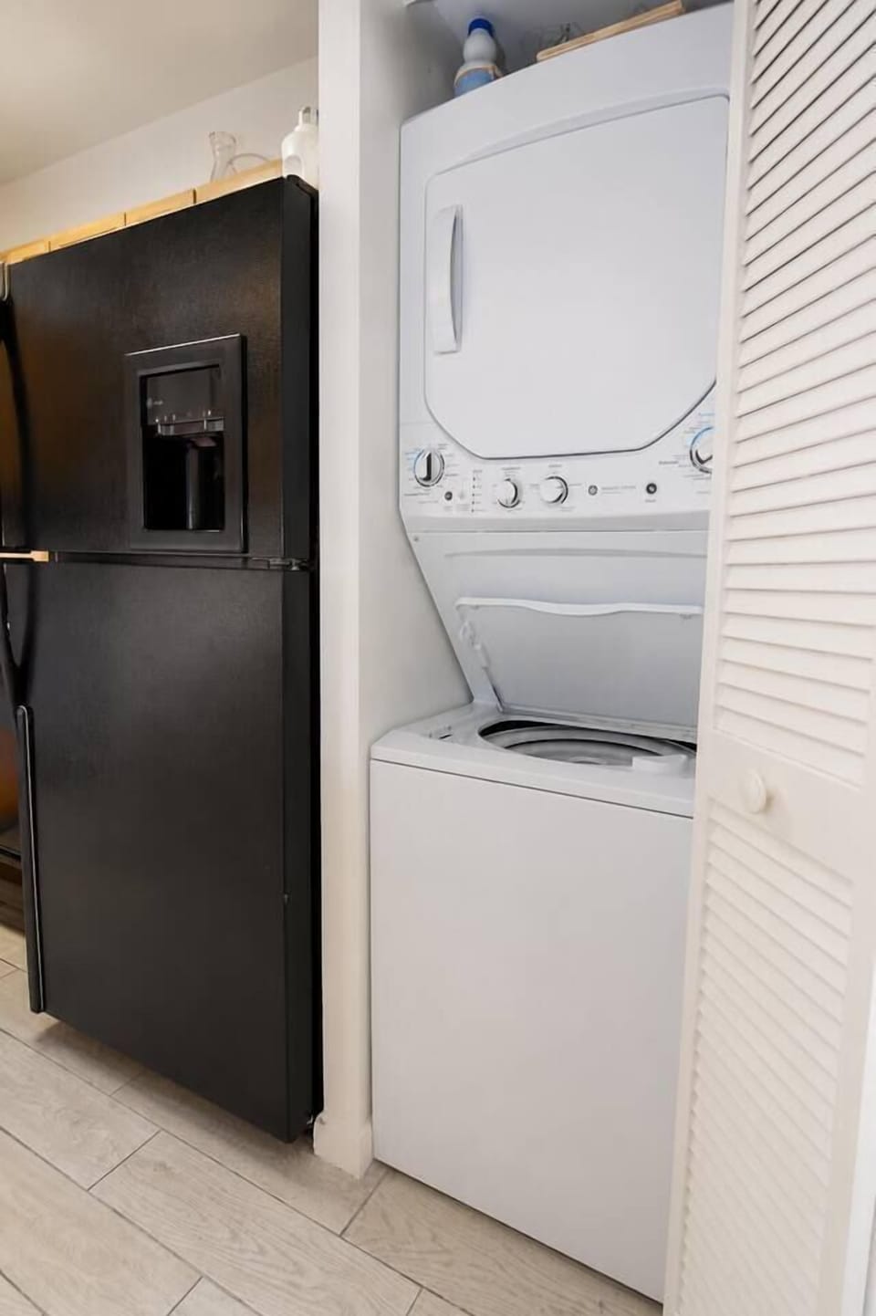 Keep your beach essentials fresh with the convenient in-unit stacked washer and dryer. This tidy laundry area features easy access to a black refrigerator and wood-look tile flooring, making long-term stays in Miami Beach a total breeze.