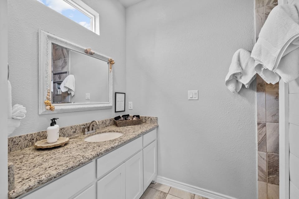 King master suite bathroom with one sink vanity and large shower. Shampoo, conditioner, body wash.