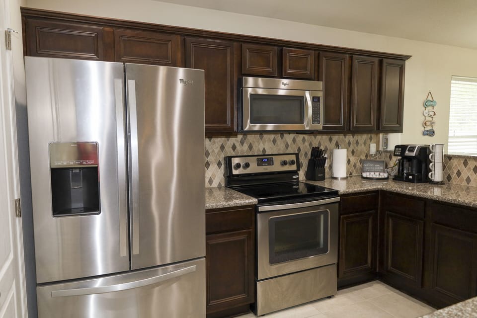 Modern kitchen with  coffee, full refrigerator, oven, microwave, dishwasher