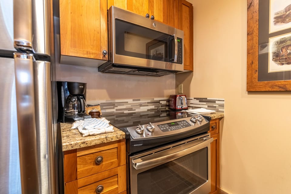 Your fully equipped kitchen makes meal prep a breeze with stainless steel appliances, granite counters, and warm wood cabinetry.