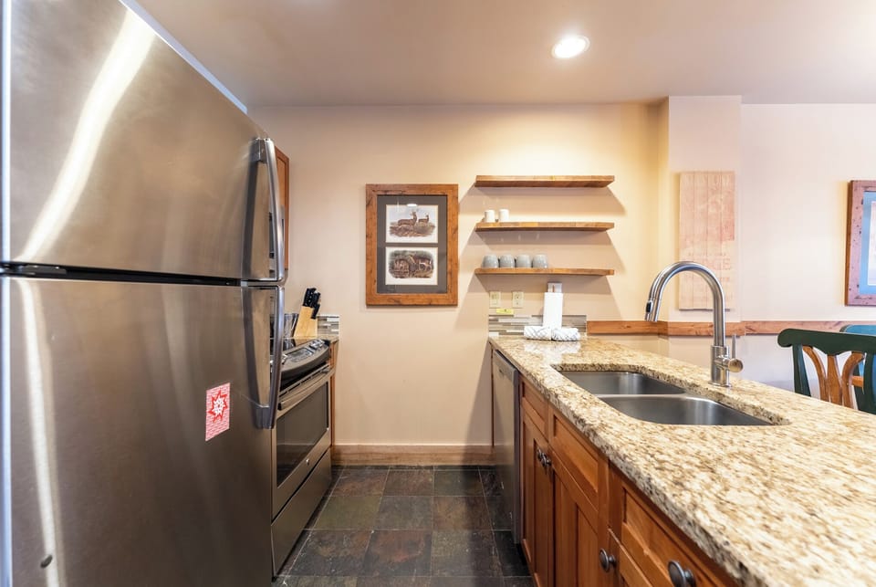 Your fully equipped kitchen features granite counters, stainless steel appliances, and open shelving for easy meal preparation.