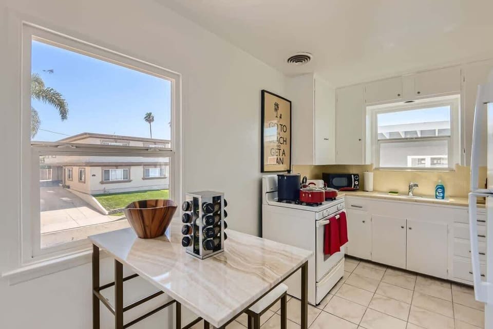 Enjoy the full kitchen with a seating area, a refrigerator, oven, stove, microwave, coffee, creamers, mixers, spices, pots, pans, cooking supplies, cutlery, cups, plates, bowls, utensils, small appliances, and many more essentials.