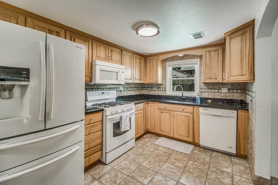 Well stocked kitchen with place settings for 16 people. Pool view to keep an eye on the kids splashing and playing.