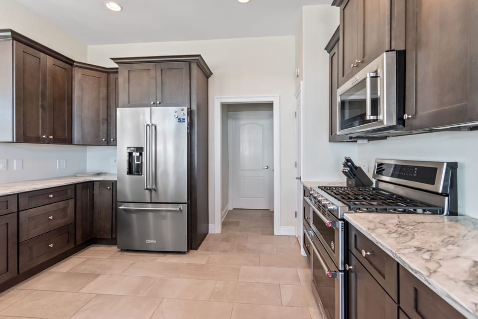 High end SS appliances, custom cabinetry and marble countertops