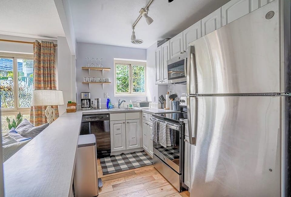 Cook and entertain with ease in this modern, fully equipped kitchen featuring stainless steel appliances, ample counter space, and a convenient open layout that flows seamlessly into the living area.
