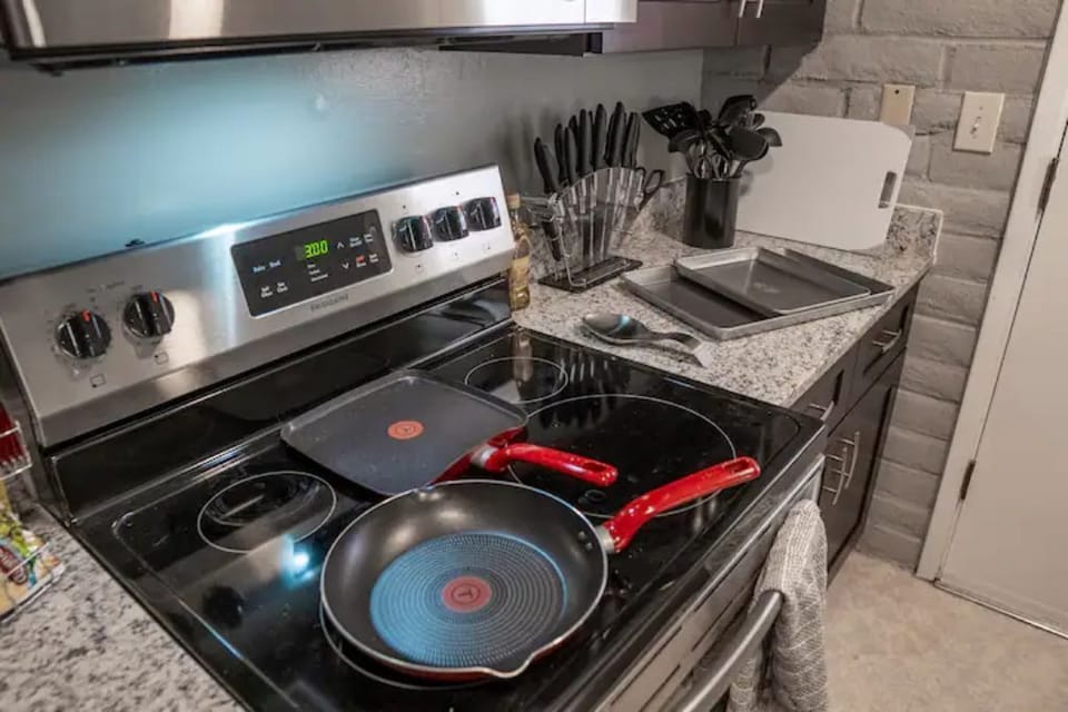 Fully-stocked kitchen with pots/pans, food prep utensils and bowls/plates