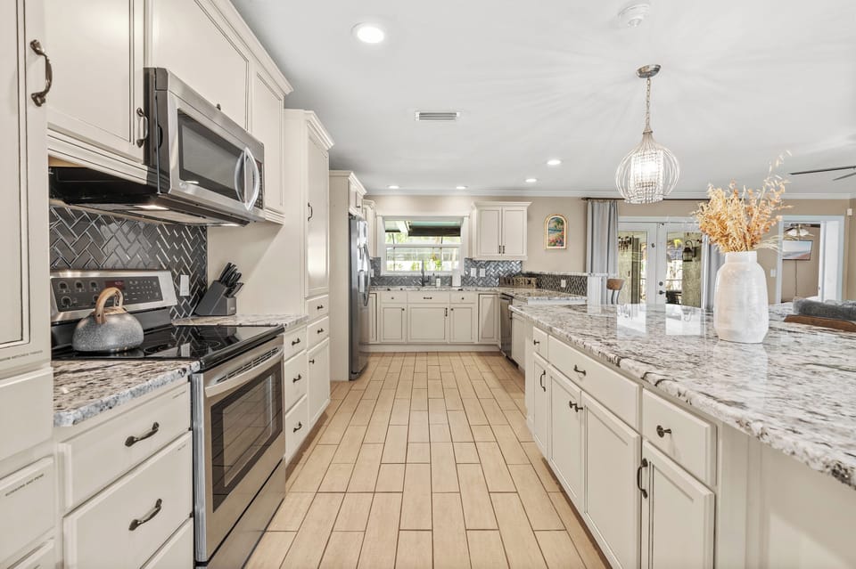 Multiple kitchen sinks located in this long kitchen space. Coffee maker and coffee provided for guest use.