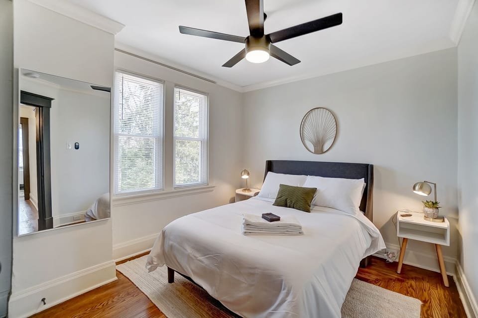 Bedroom w/ a full sized bed, full length mirror, closet & flat screen TV