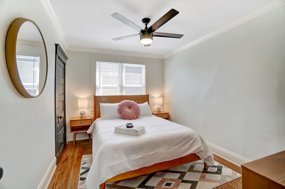 Bedroom with queen size bed, closet with luggage rack and hangers. 