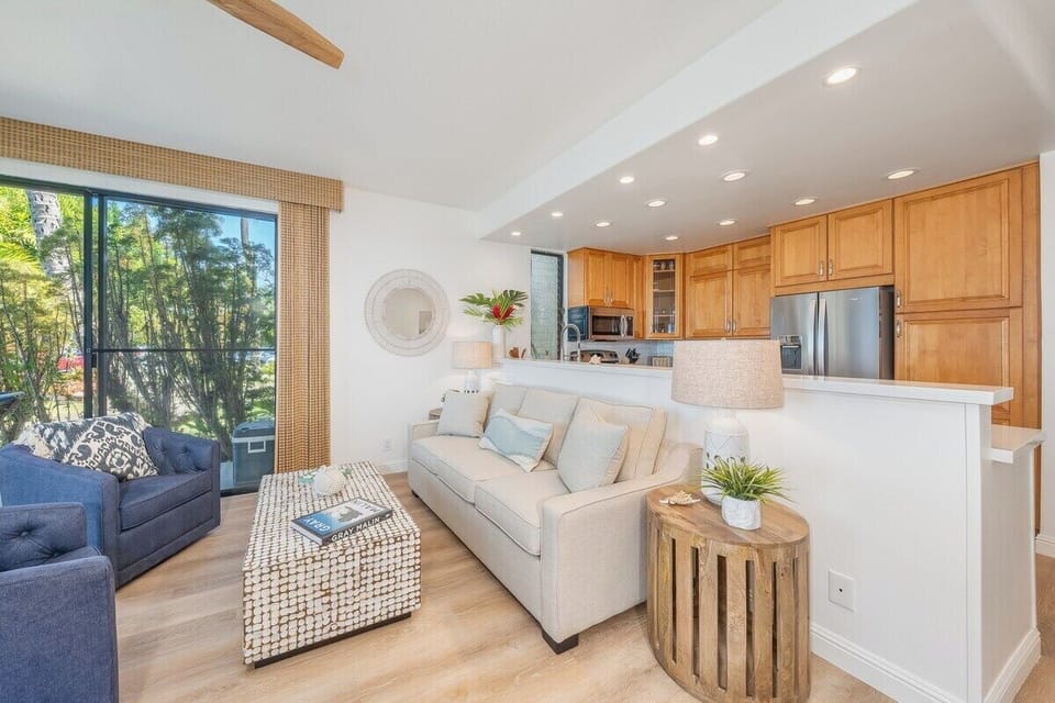 Open layout blending living and kitchen spaces, styled with neutral tones, wicker textures, and decorative details