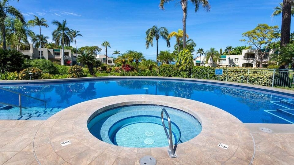 Circular hot tub integrated into lush pool setting
