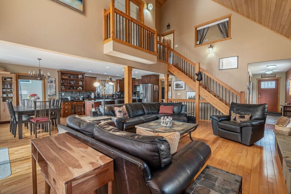 Main floor living space`s open floor plan with cozy seating options, fireplace & access to the private patio.