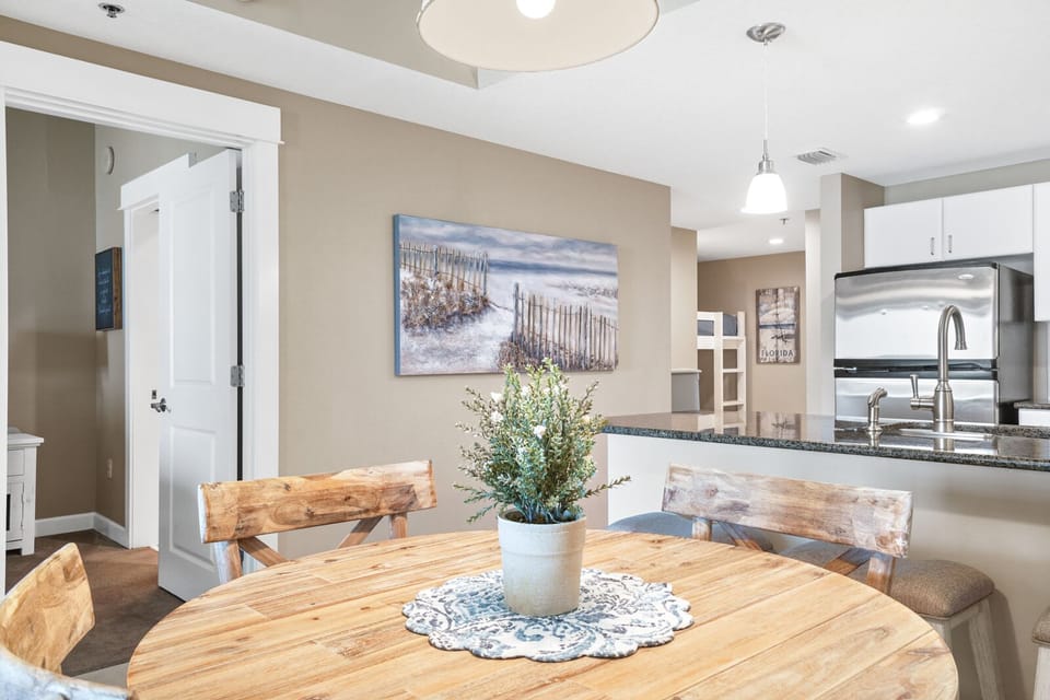 Gather around your rustic wood dining table where warm morning light illuminates the open kitchen beyond—perfect for sharing meals together.