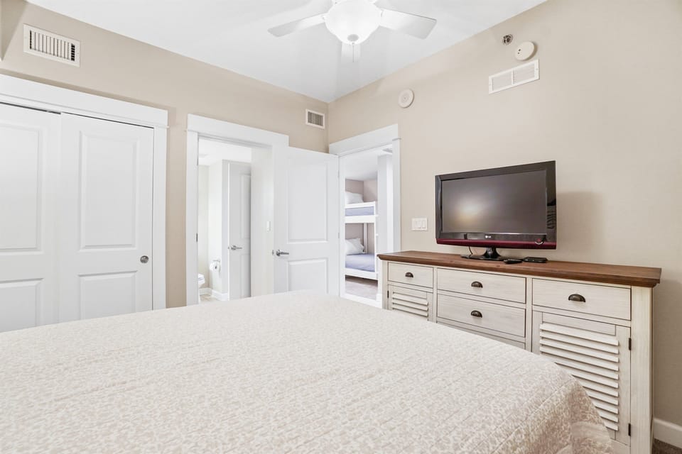Relax in your spacious bedroom featuring a comfortable bed, flat-screen TV, and convenient storage. The adjacent bathroom ensures privacy and comfort.