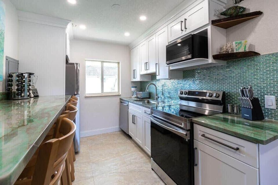 Modern kitchen with green countertops and a teal tile backsplash